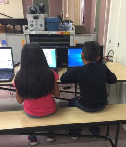 boy and girl on computers playing our games