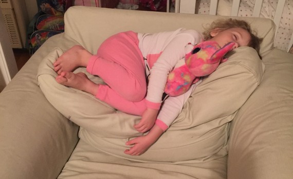 child asleep on the back of a chair