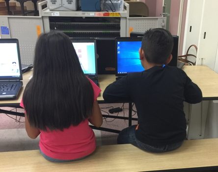 boy and girl on computers playing our games