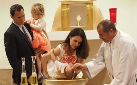 Father Mike baptizing Maria's baby