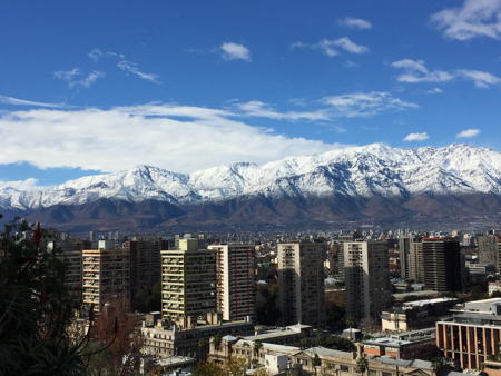 snow on mountains behind the skyscrapers in Santiago, Chile