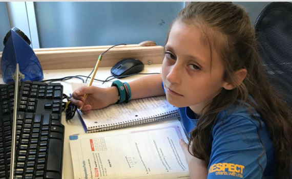student doing a workbook looking bored